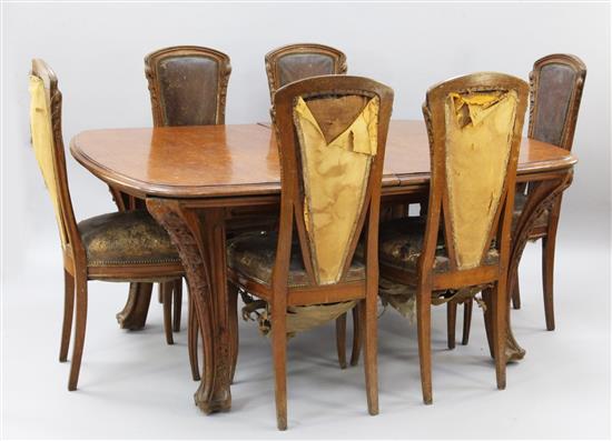 A Louis Majorelle Chicoree pattern oak dining table and six chairs, 5ft 2in. x 4ft 2in., extends to 12ft